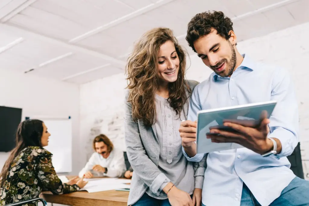 Mann und Frau im Büro mit Tablet Mann und Frau schauen gemeinsam im Büro auf ein Tablet